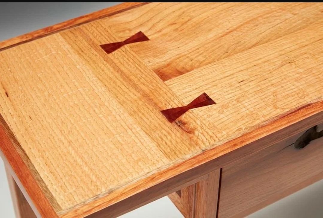 Close-up of the entry console table top showing contrasting bowtie inlays across the oak boards