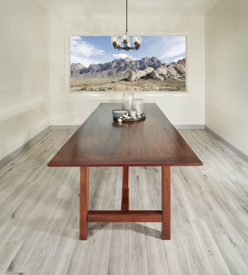 Mahogany dining table seen from the end, in a dining room with a mountain view