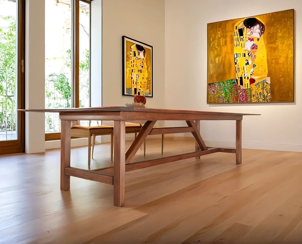 Mahogany dining table with trestle base in a bright room with large paintings
